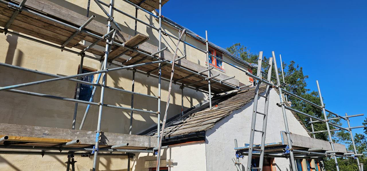 Render repair work in progress with scaffold on a Lancashire home